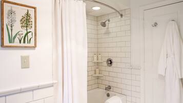 A bathroom with a shower, a bathtub, and a towel rack.