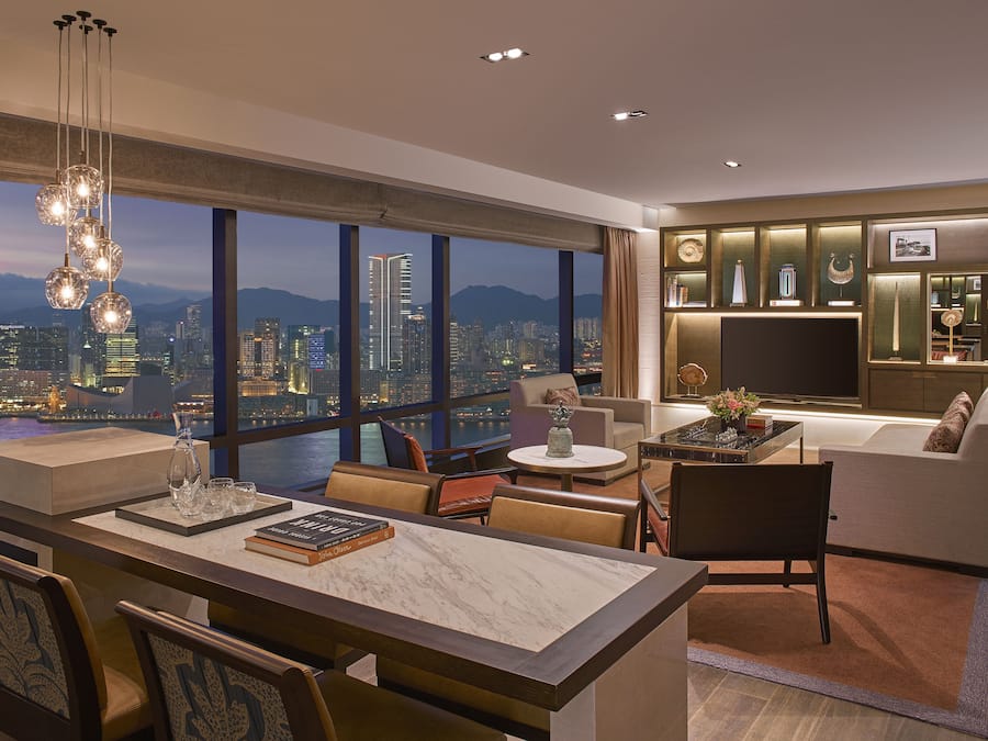 Ein modernes Wohnzimmer mit Blick auf die Stadt, ein Essbereich mit einem Marmortisch und eine gemütliche Sitzecke.