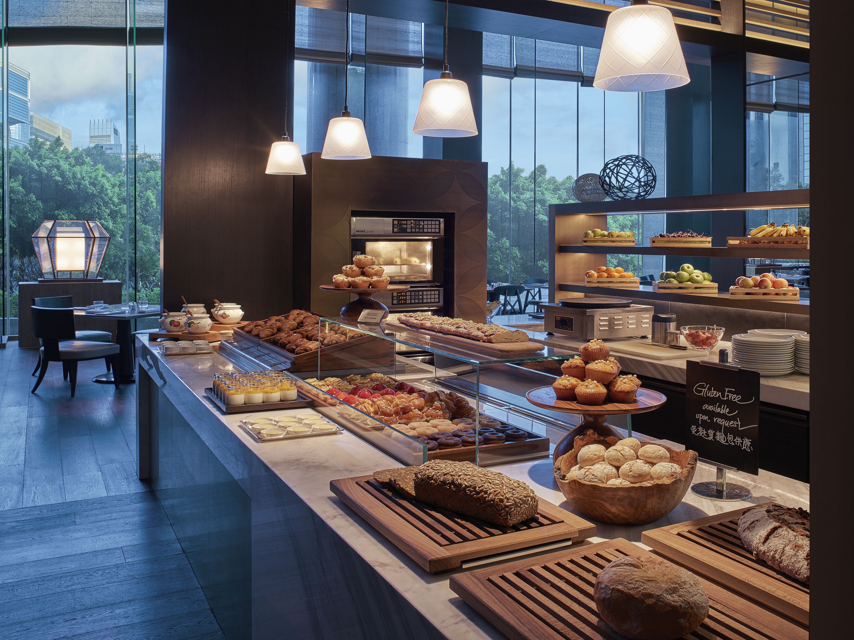 A breakfast buffet with various pastries, fruits, and gluten-free options available upon request.