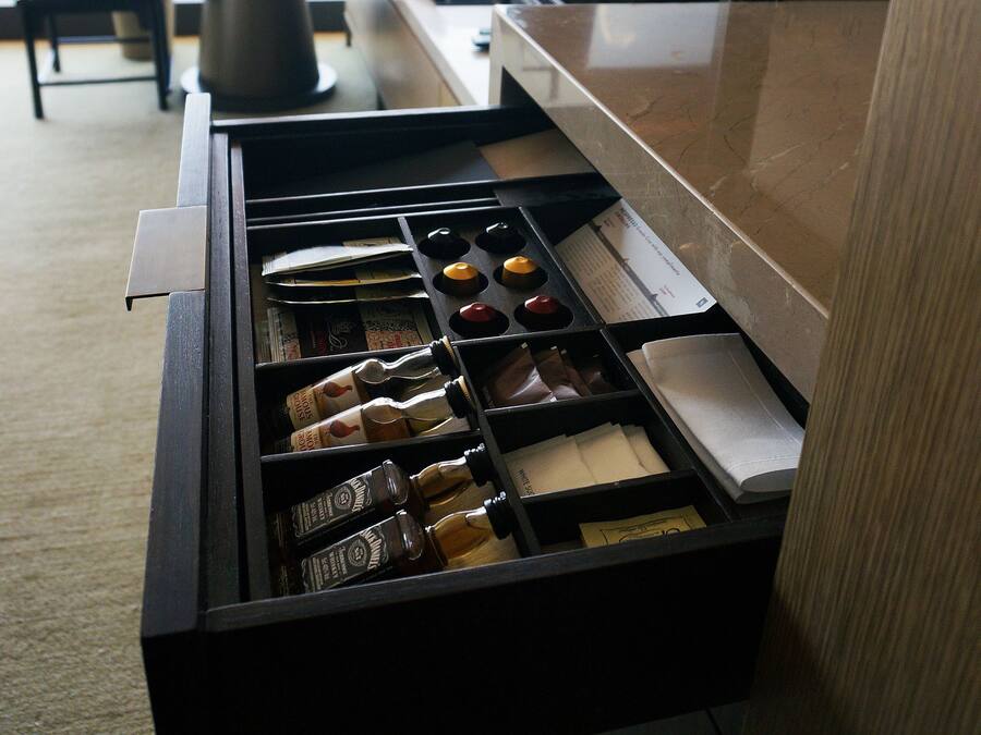 Un minibar fornito di bevande e snack assortiti.