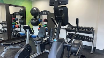 A gym with cardio equipment, weightlifting stations, and exercise balls.