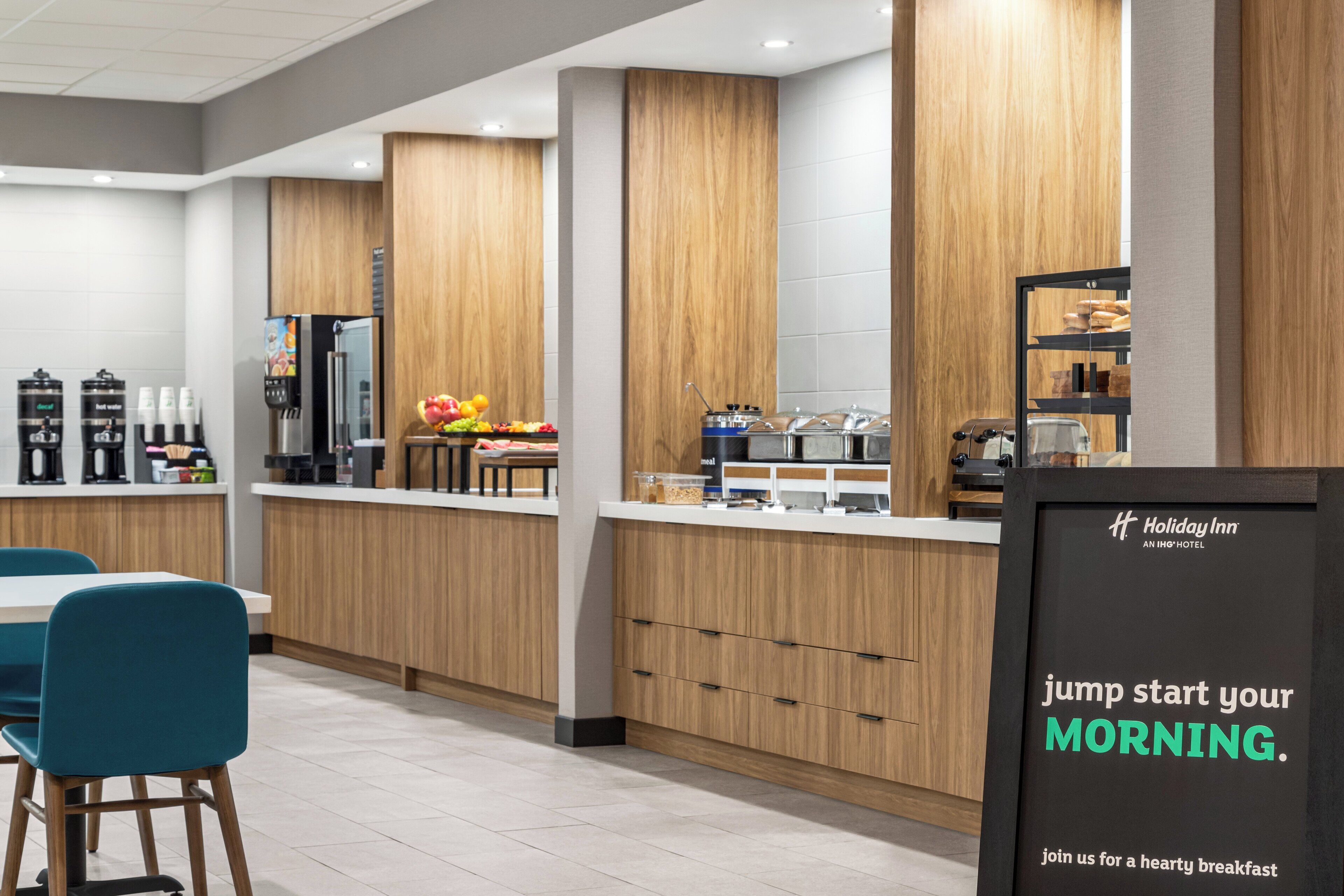 A modern breakfast area with wooden cabinets, a coffee station, and a sign promoting a hearty breakfast.