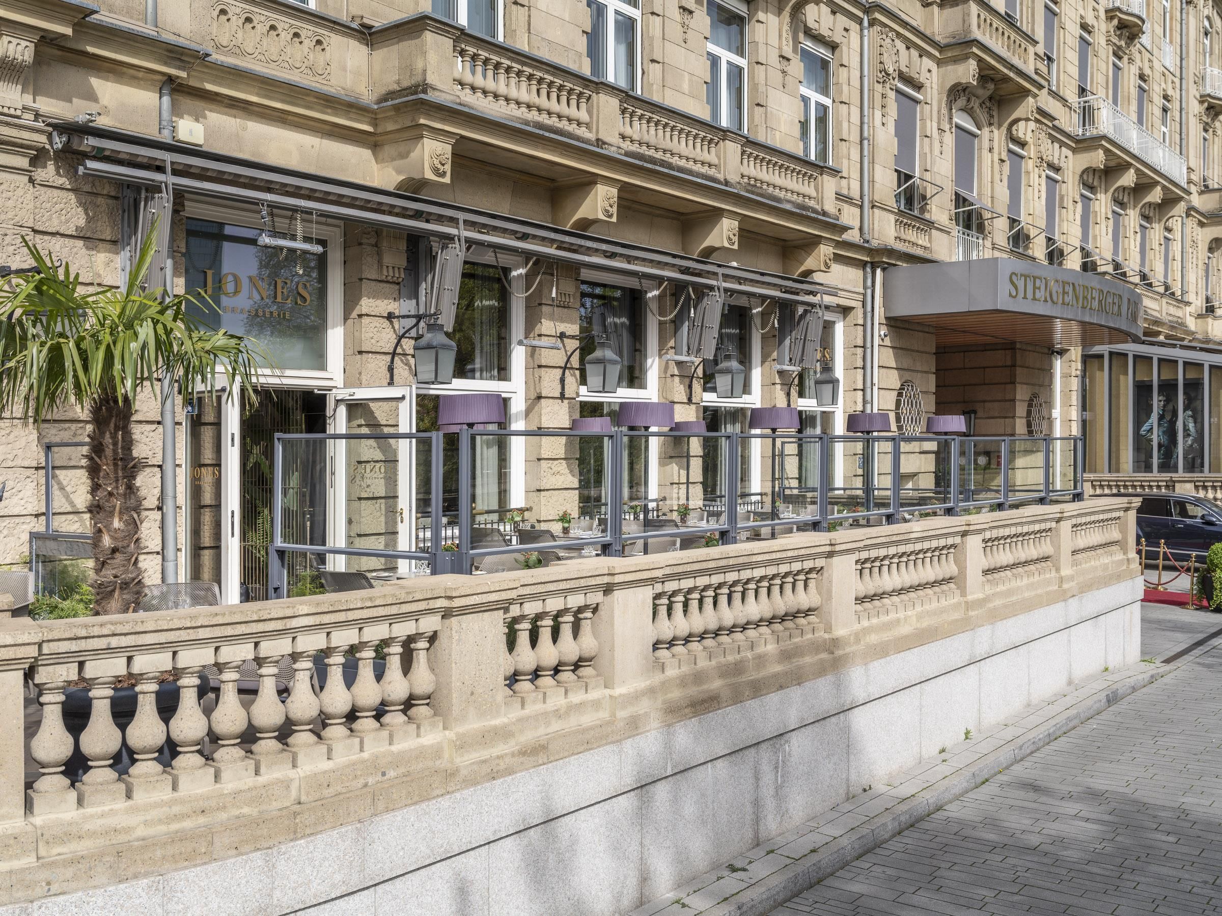 Un edificio storico con facciata classica, un ingresso imponente e un balcone con posti a sedere.