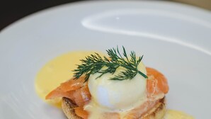 A plate with a dish consisting of smoked salmon, poached egg, and hollandaise sauce. - Steigenberger Icon Parkhotel Düsseldorf (Düsseldorf)
