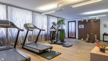 A gym with treadmills, a stationary bike, and a weight bench.