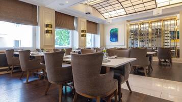 Un interior de restaurante con suelo de madera, mesas redondas y sillas.
