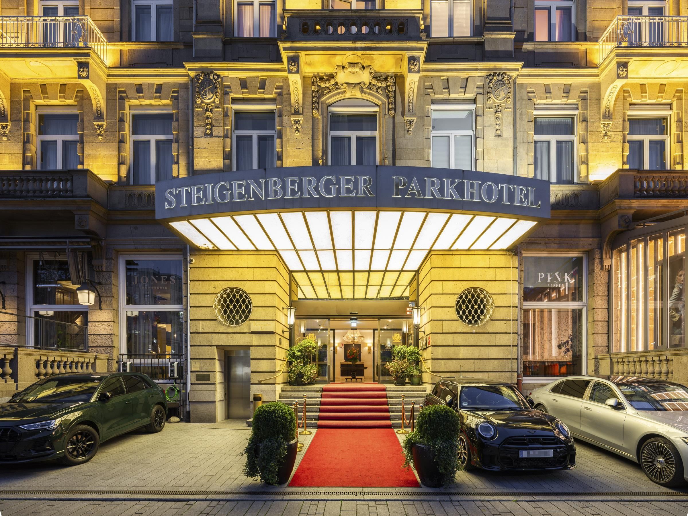 The Steigenberger Parkhotel entrance with a red carpet, double doors, and a classic facade.