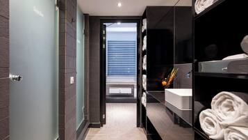 Une salle de bain moderne avec une porte en verre, un lavabo et des serviettes.