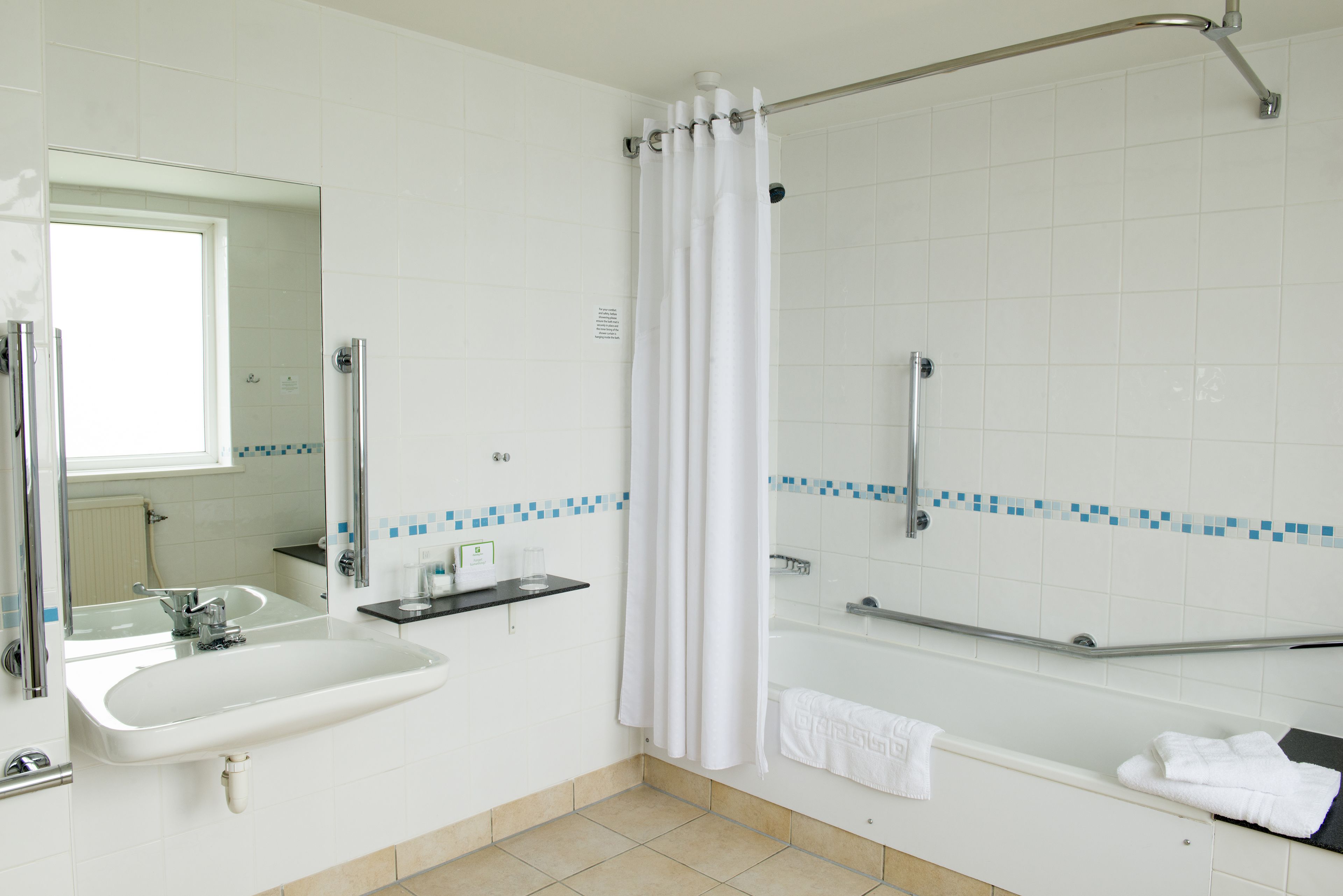 Ein Badezimmer mit Waschbecken, Spiegel, Dusche und Badewanne.