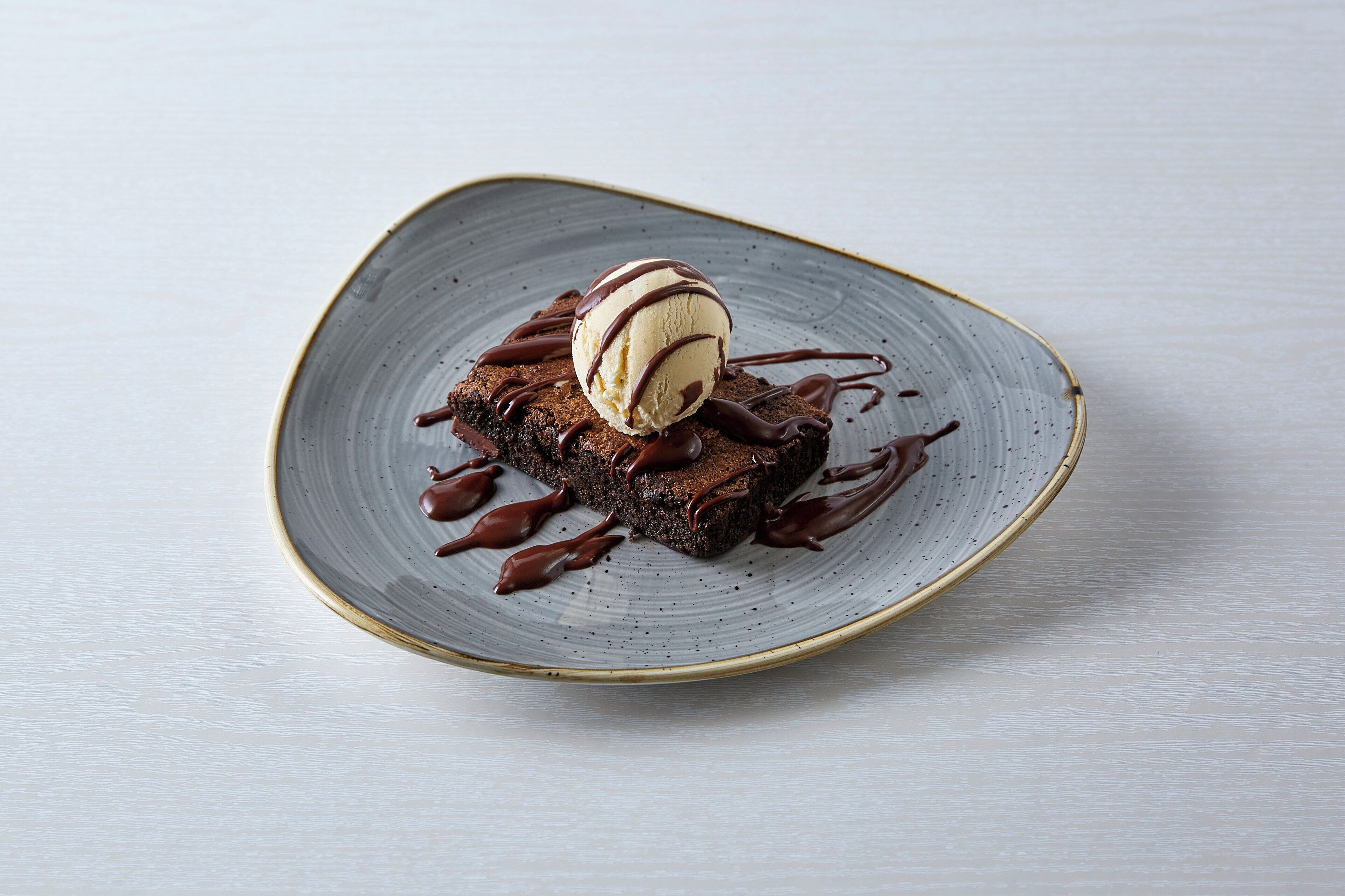 Un postre en un plato con salsa de chocolate.