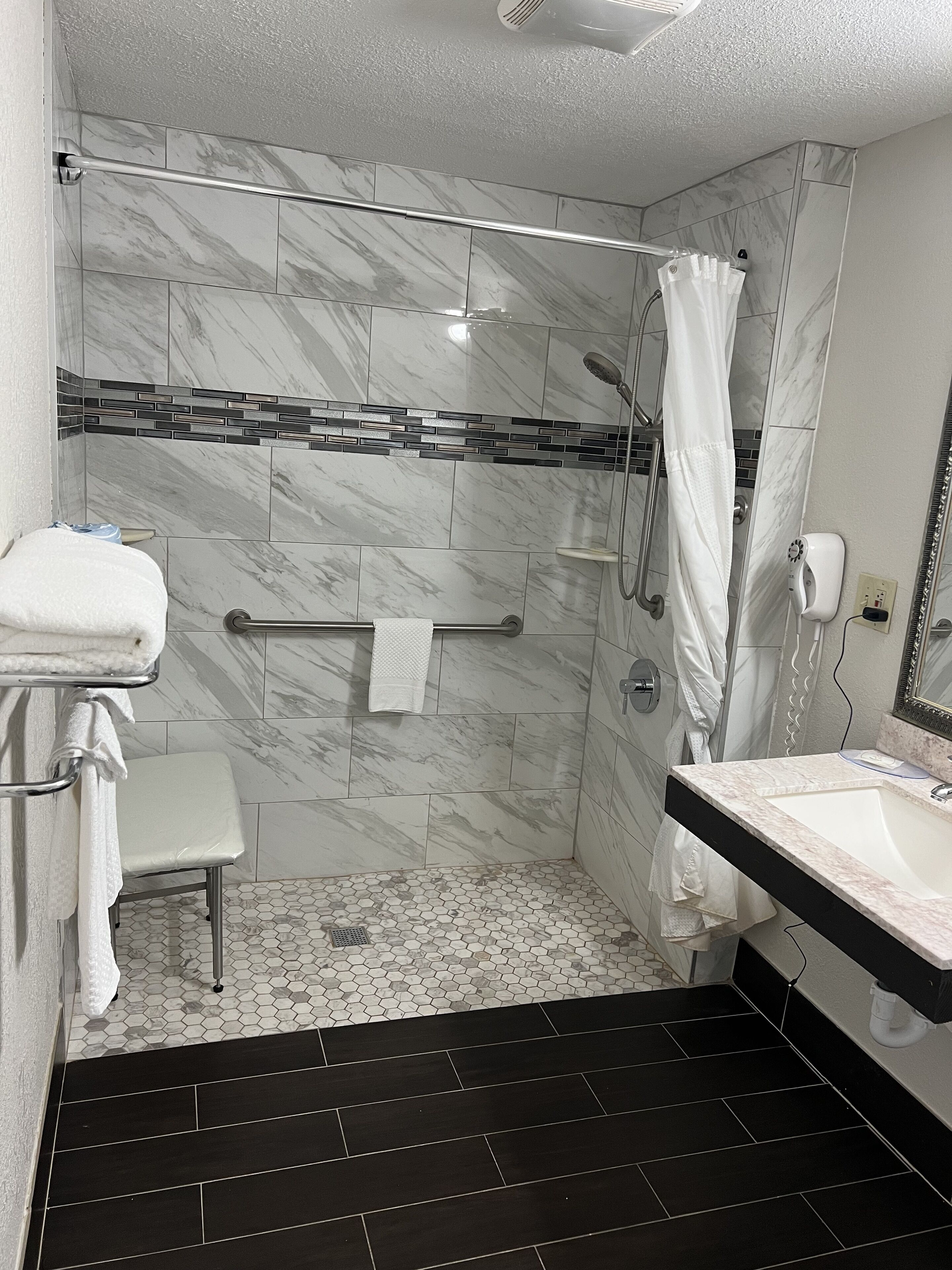 A modern bathroom with a shower, toilet, and sink.