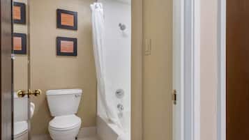 A bathroom with a toilet, a bathtub, and a shower curtain.