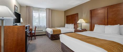 A hotel room with two beds, a desk, a chair, a TV, and a window with curtains.