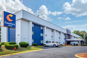 A Comfort Inn hotel with a large blue entrance, a white building, and a parking lot.