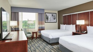 A hotel room with two beds, a desk with a laptop, a chair, a small table, and a window with curtains. - DoubleTree by Hilton Raleigh Crabtree Valley (Raleigh)