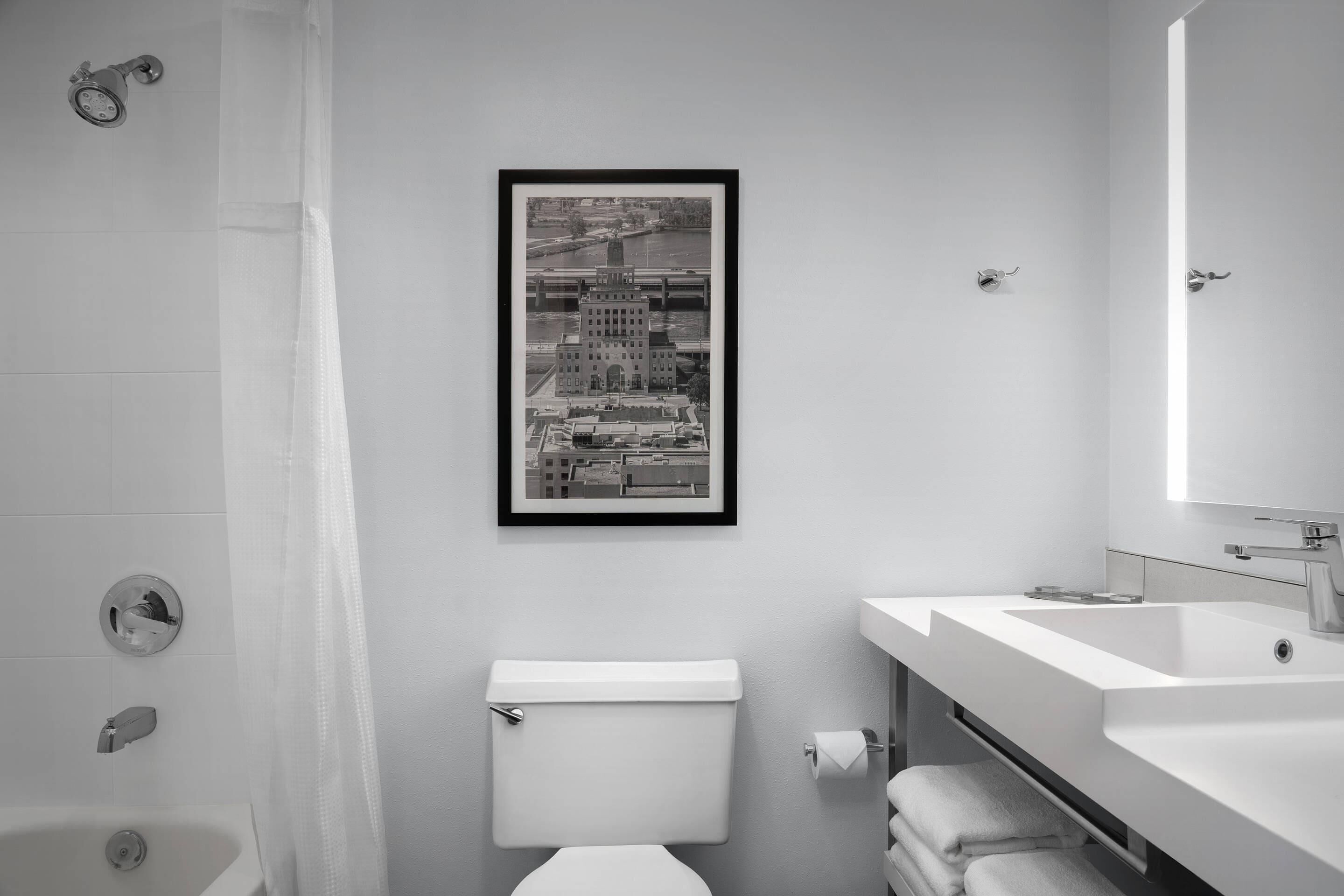 A modern bathroom with a toilet, sink, and shower.