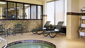 A spa area with a hot tub, lounge chairs, and exercise equipment. - Radisson Hotel Cedar Rapids (Cedar Rapids)