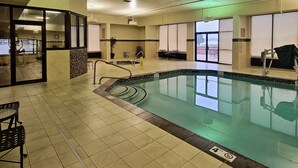 An indoor swimming pool with tiled flooring, a pool ladder, and a bench. - Radisson Hotel Cedar Rapids (Cedar Rapids)