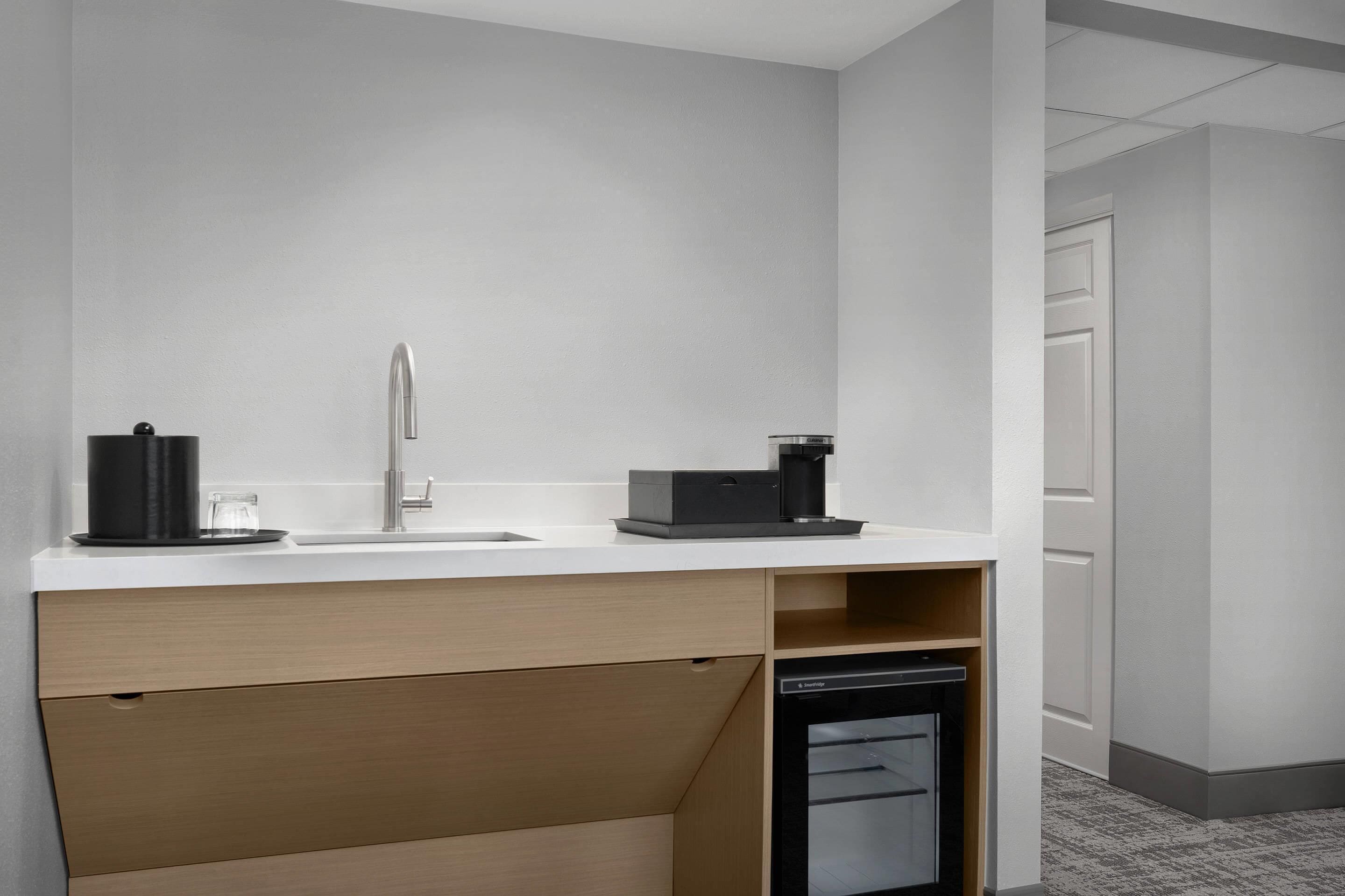 A modern kitchen with a sink, a coffee machine, and a dishwasher.