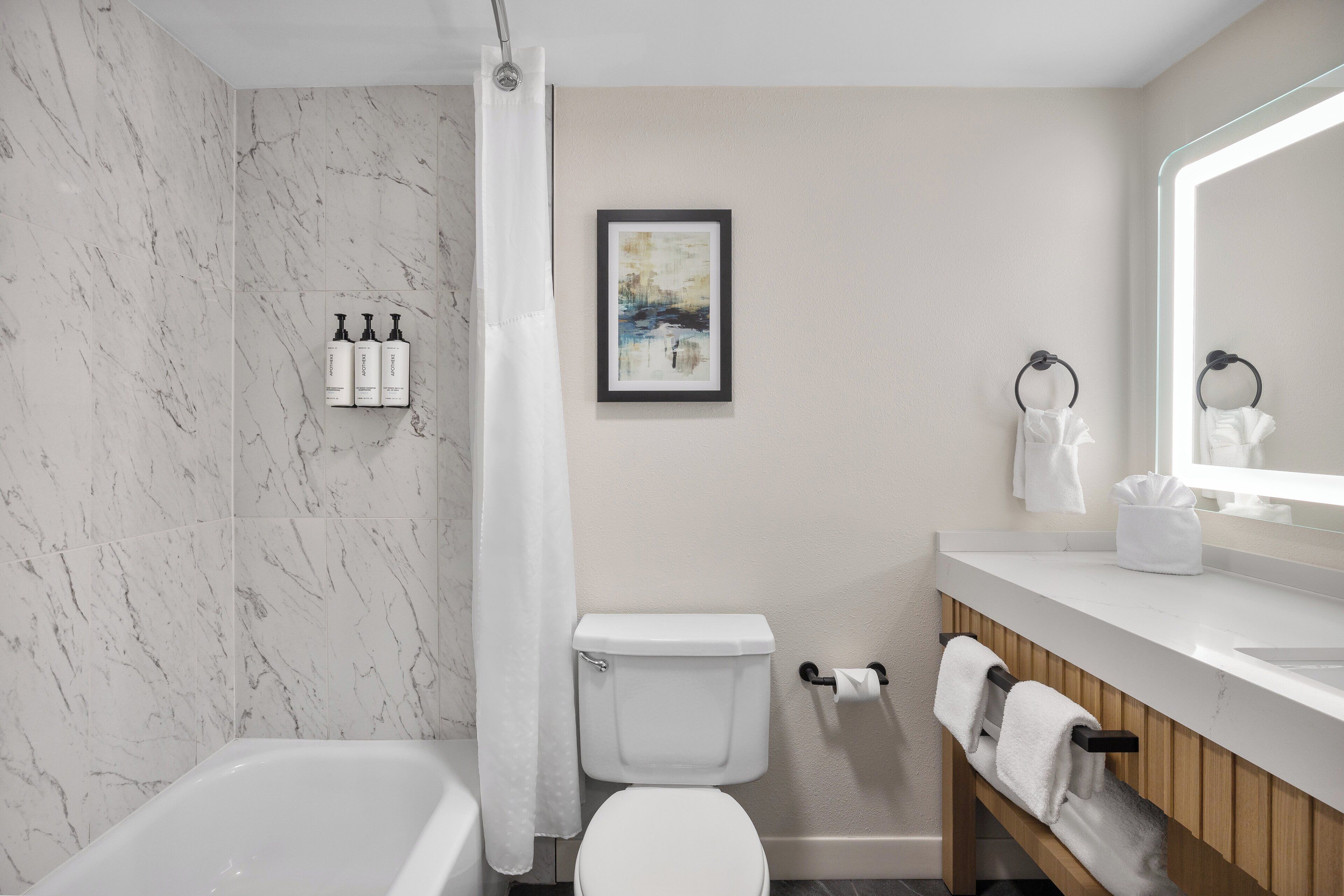 Ein modernes Badezimmer mit Badewanne, Toilette und Waschtisch.