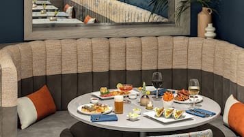 A dining area with a round table set for a meal, surrounded by cushioned seating.