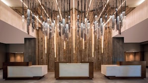 Un área de recepción de diseño moderno, con un muro de madera y un mostrador con encimera de mármol.