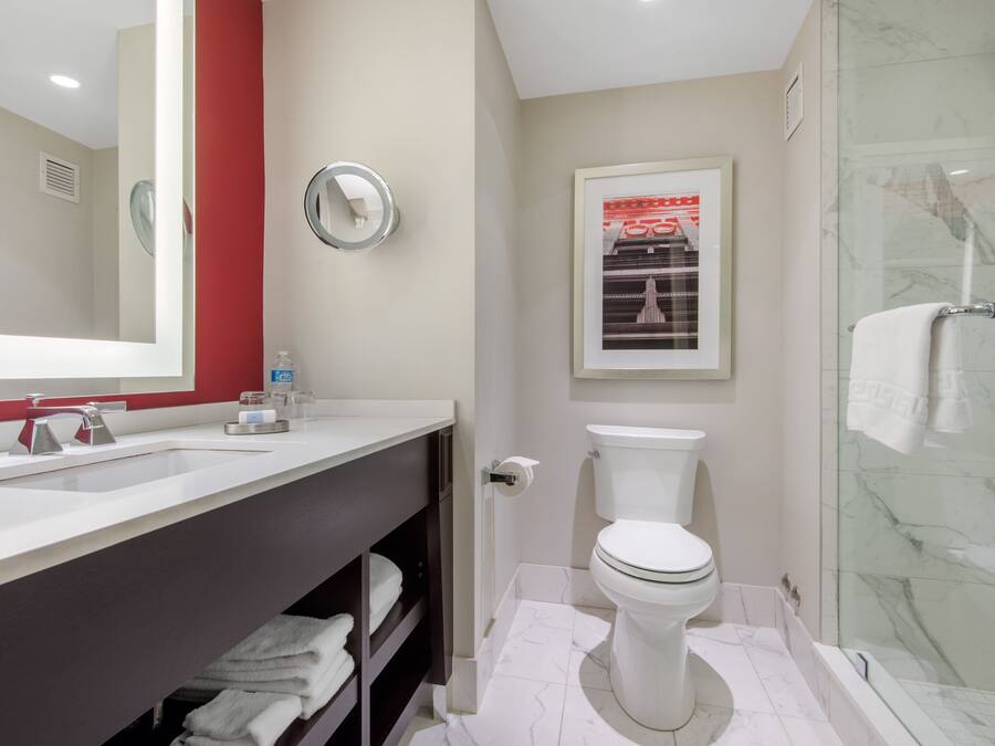 A modern bathroom with a white sink, a toilet, and a glass shower enclosure.
