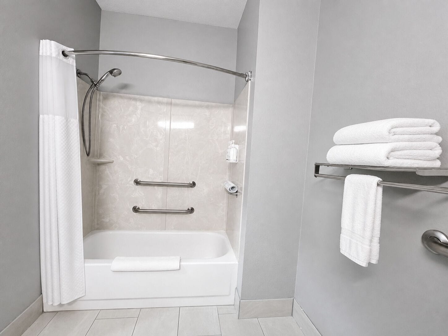 Une salle de bain moderne avec une douche à l’italienne, une baignoire et un porte-serviettes.
