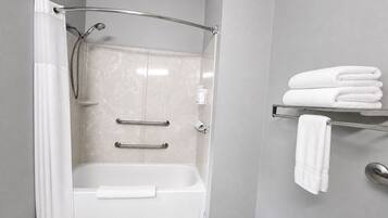 Une salle de bain moderne avec une douche à l’italienne, une baignoire et un porte-serviettes.