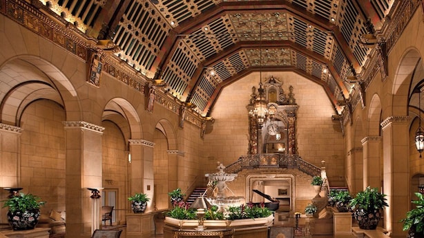 Un hall d’entrée somptueux, agrémenté d’un magnifique escalier, d’un piano et d’une architecture de style classique.