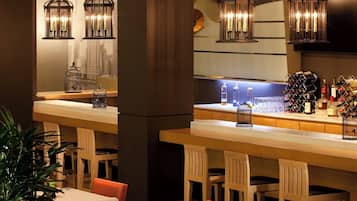 A bar area with hanging lanterns, a cityscape view, and a wine rack.