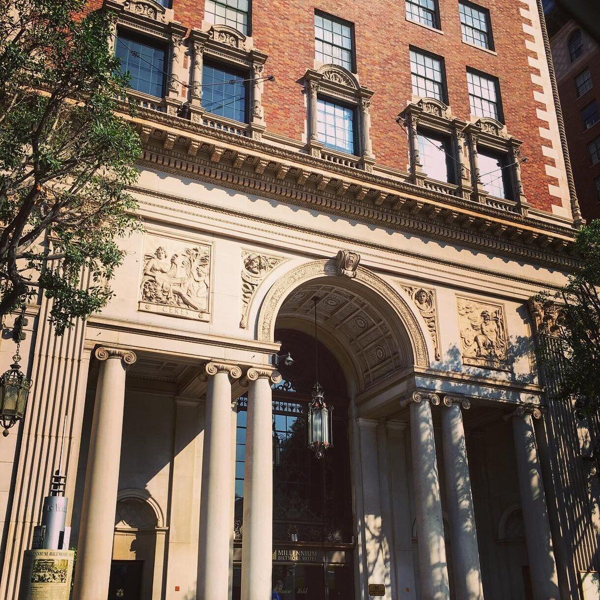 A classical building facade with columns, a central arch, and decorative sculptures.