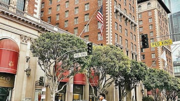 Un paso de peatones con un edificio de ladrillo, una bandera y una señal de calle.