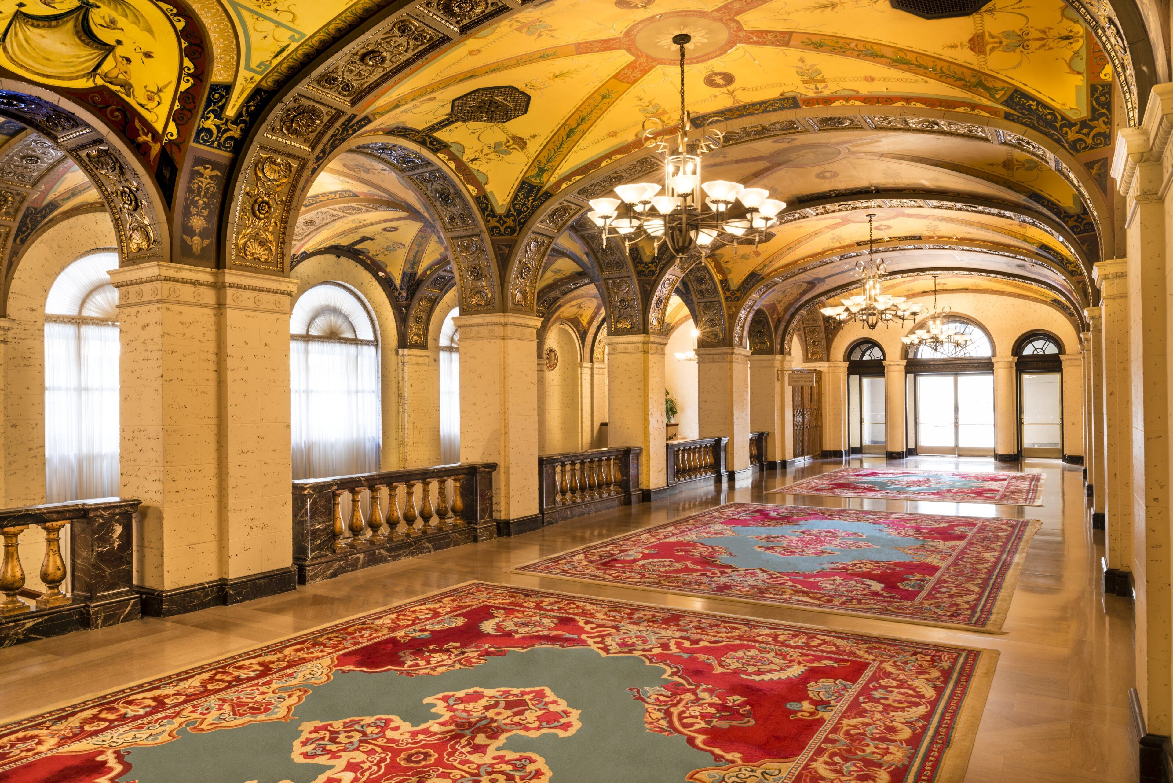 A grand hall with arched ceilings, chandeliers, and ornate columns.
