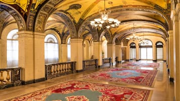 A grand hall with arched ceilings, chandeliers, and ornate columns.