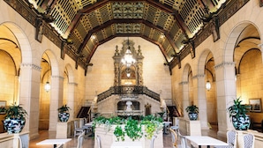 Un hall d’entrée agrémenté d’une fontaine centrale, de coins salon et de détails architecturaux raffinés.