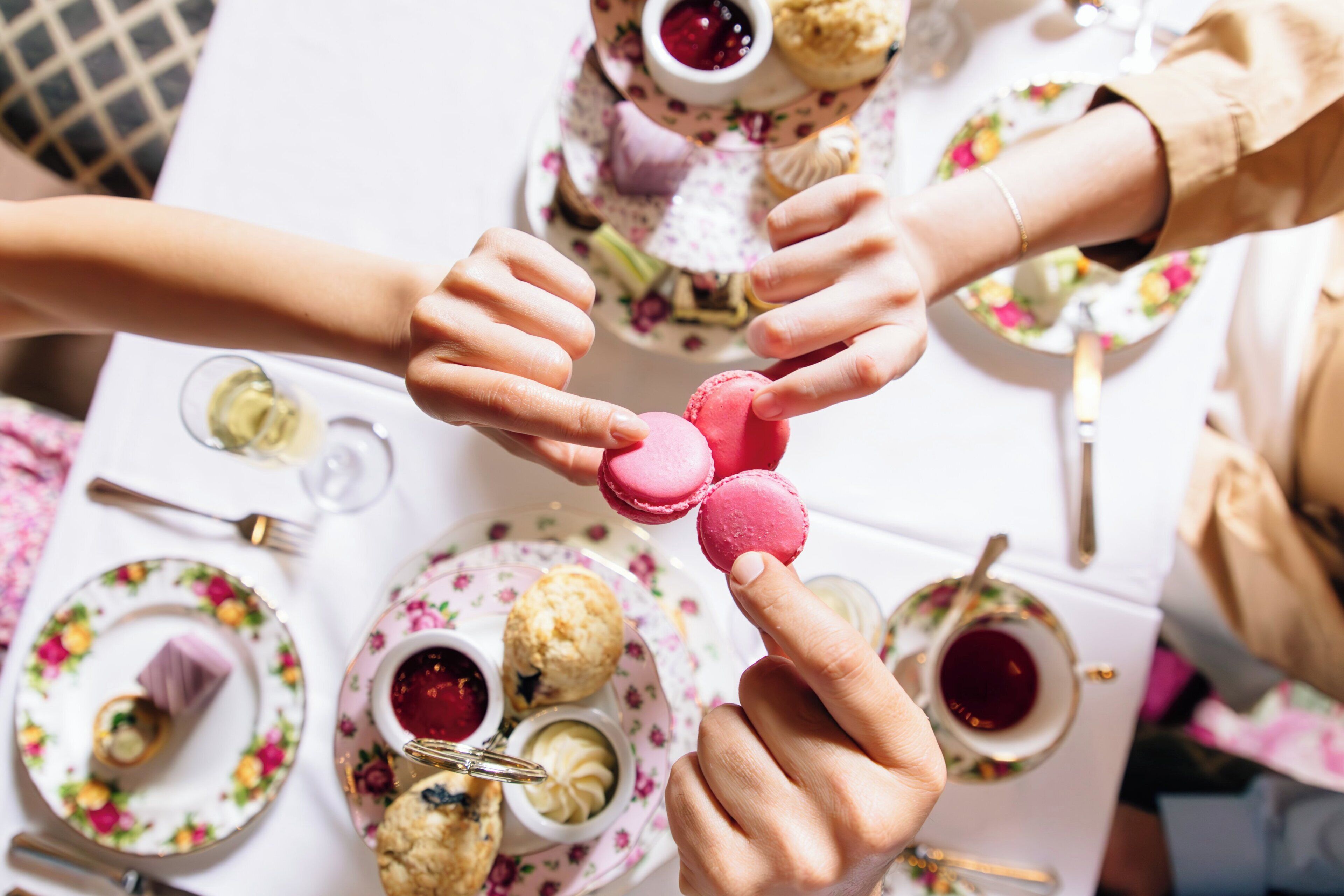 A table with floral-patterned plates, a teapot, and a cup of tea.