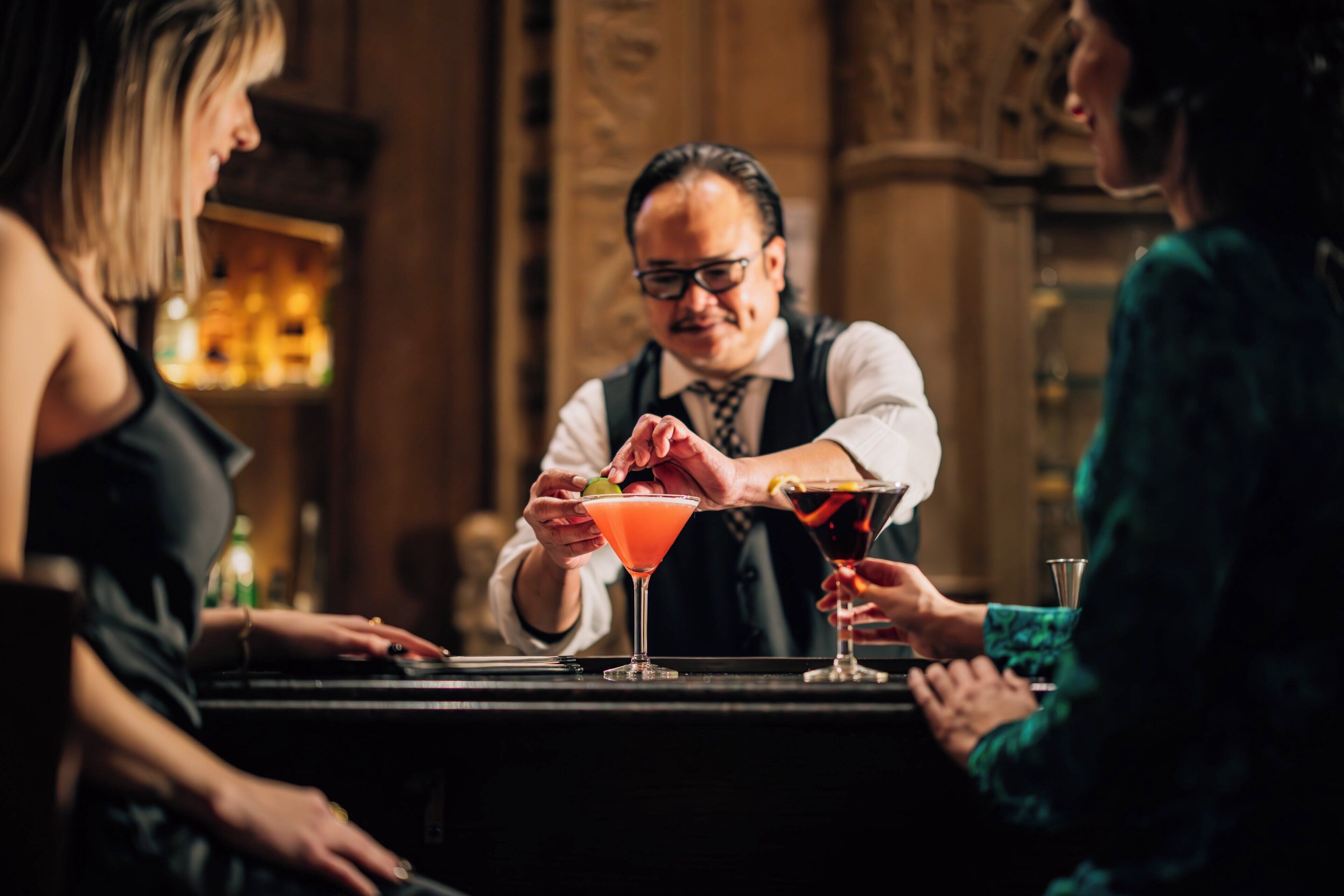 Un bar avec un barman préparant des boissons, un comptoir et un espace bar.