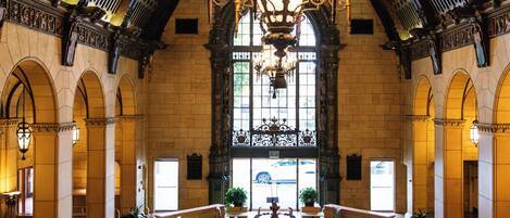 An ornate interior with a large chandelier, arched ceilings, and seating areas.