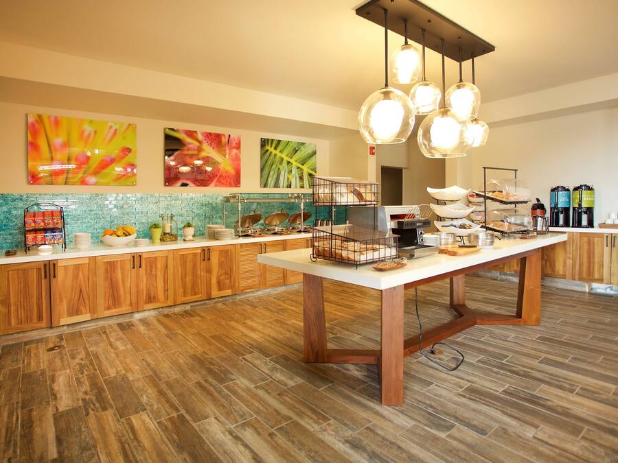 Una cocina moderna con armarios de madera, una isla central y diferentes opciones para el desayuno.