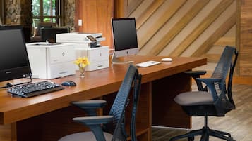 Een modern bureau met meerdere monitoren, een toetsenbord, een muis en kantoorstoelen.