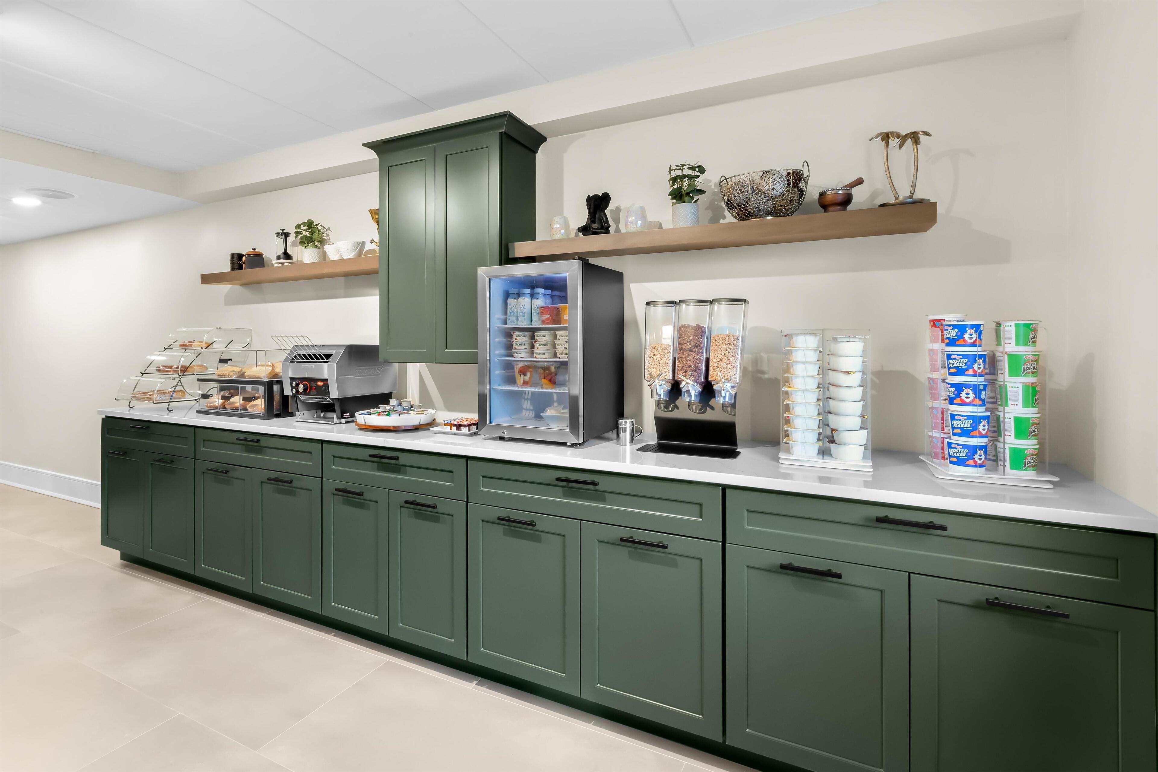 Un aparador tipus buffet amb vitrines refrigerades, diferents plats i dispensadors de begudes.