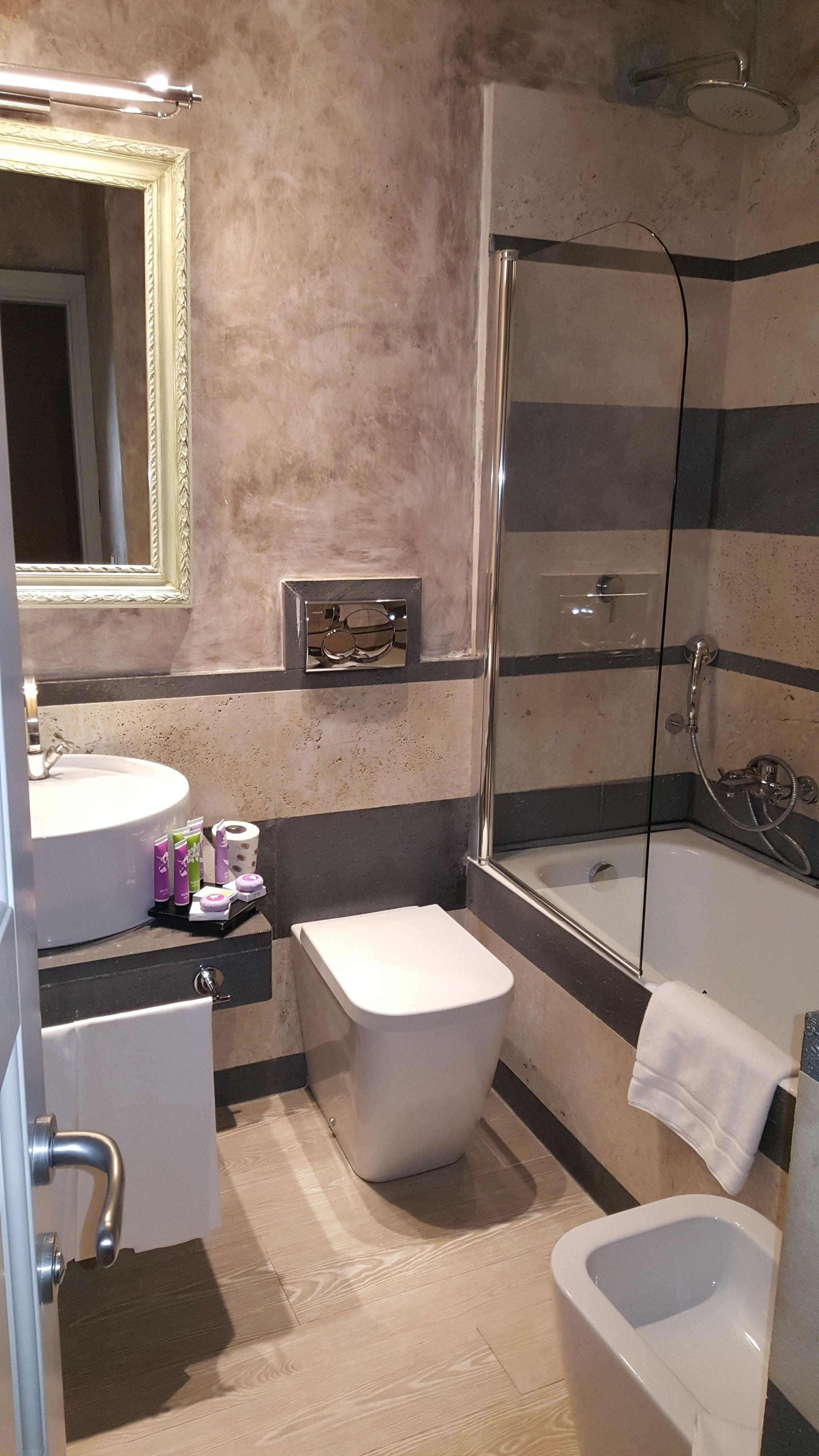 Un baño con ducha, inodoro, bidé y lavamanos.