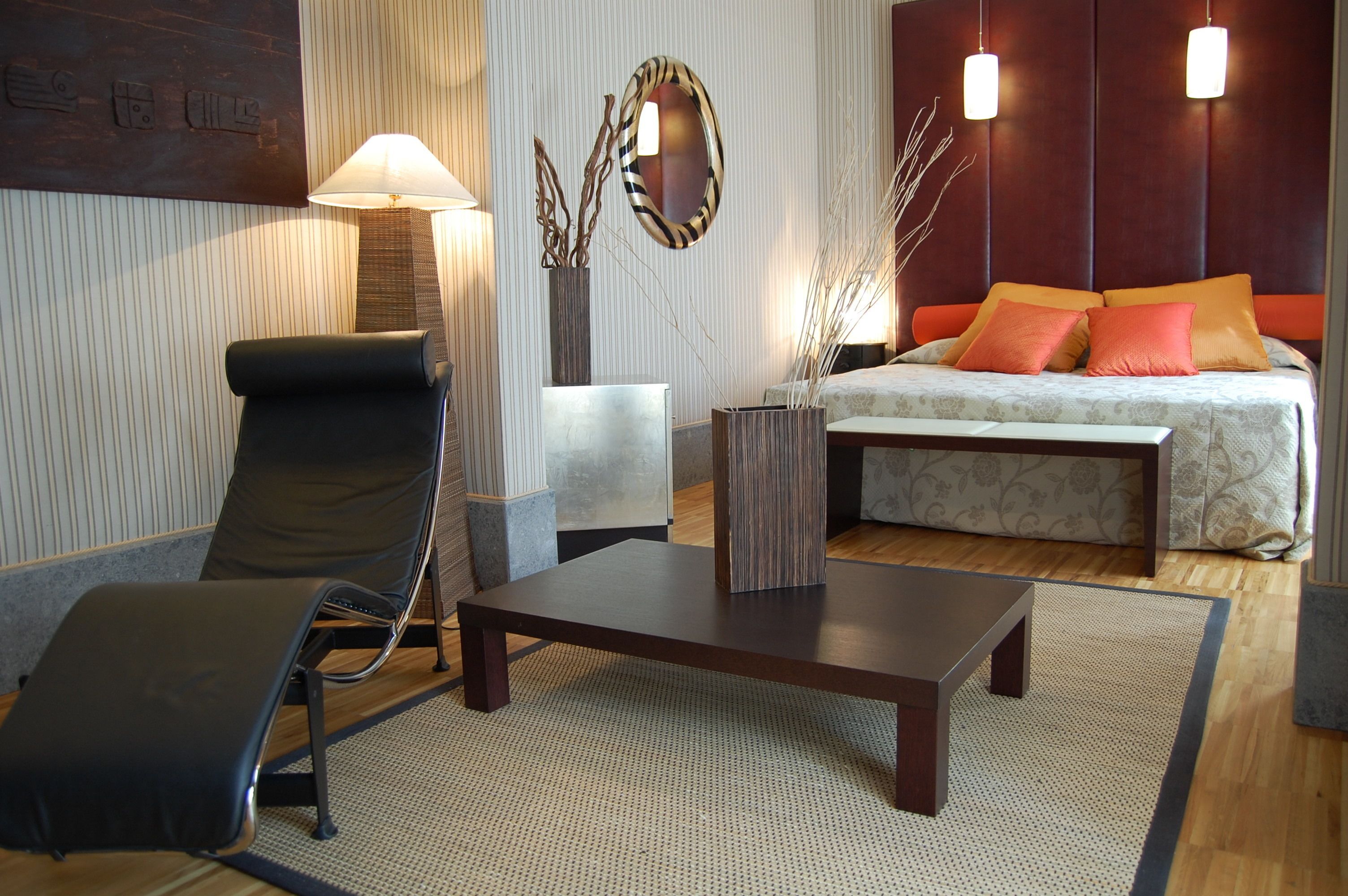 A modern living room with a sofa, a lounge chair, a coffee table, and a lamp.