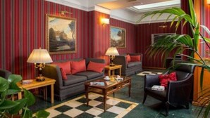 A room with striped wallpaper, a sofa, a chair, a coffee table, and two lamps. - Hotel Morgana (Rome)