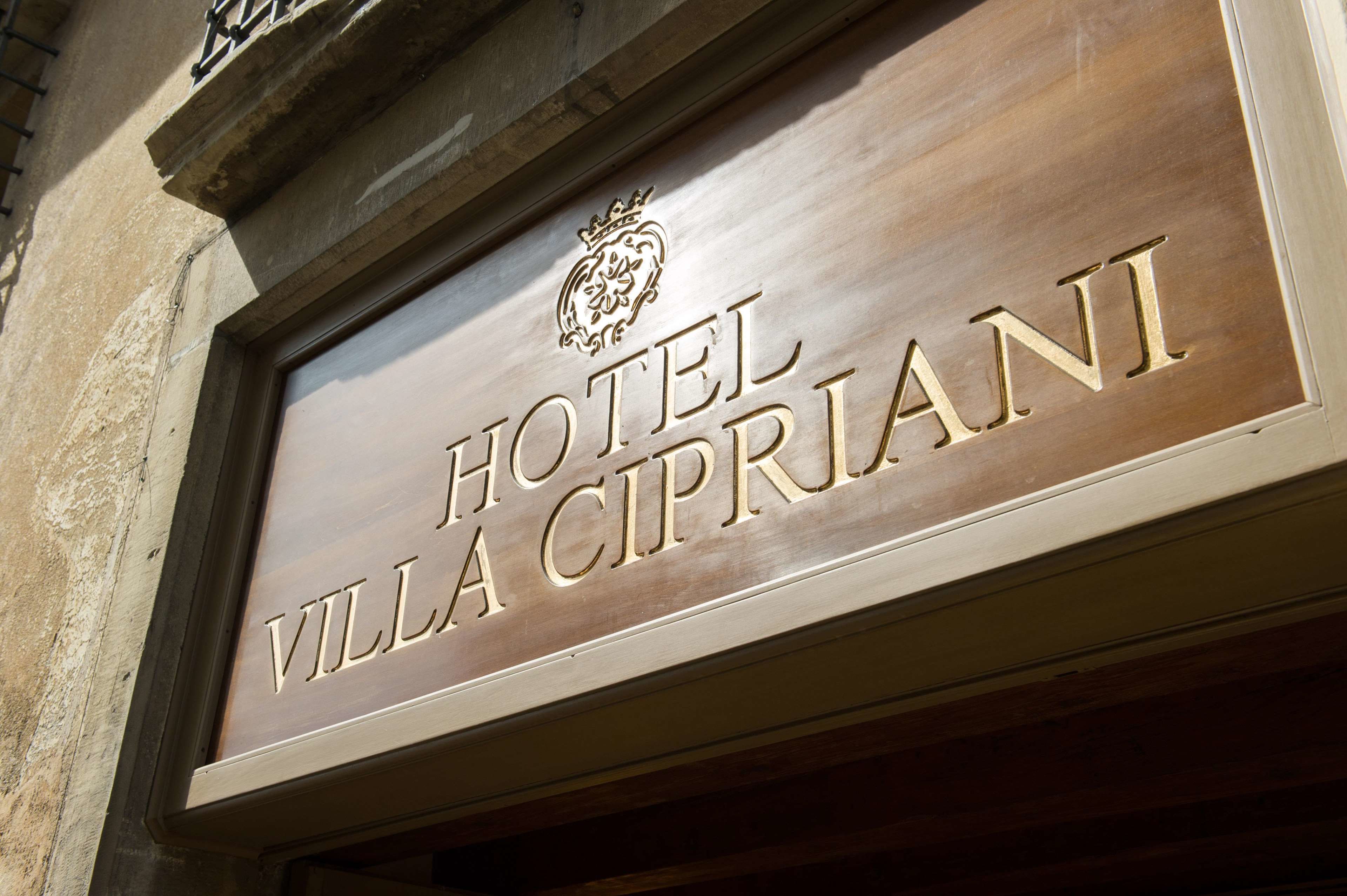 Letrero del Hotel Villa Cipriani con un emblema de escudo.
