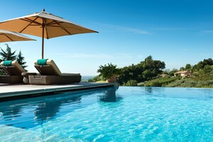 Una piscina al aire libre de temporada, sombrillas