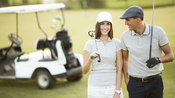 A golf cart and two people on a golf course.