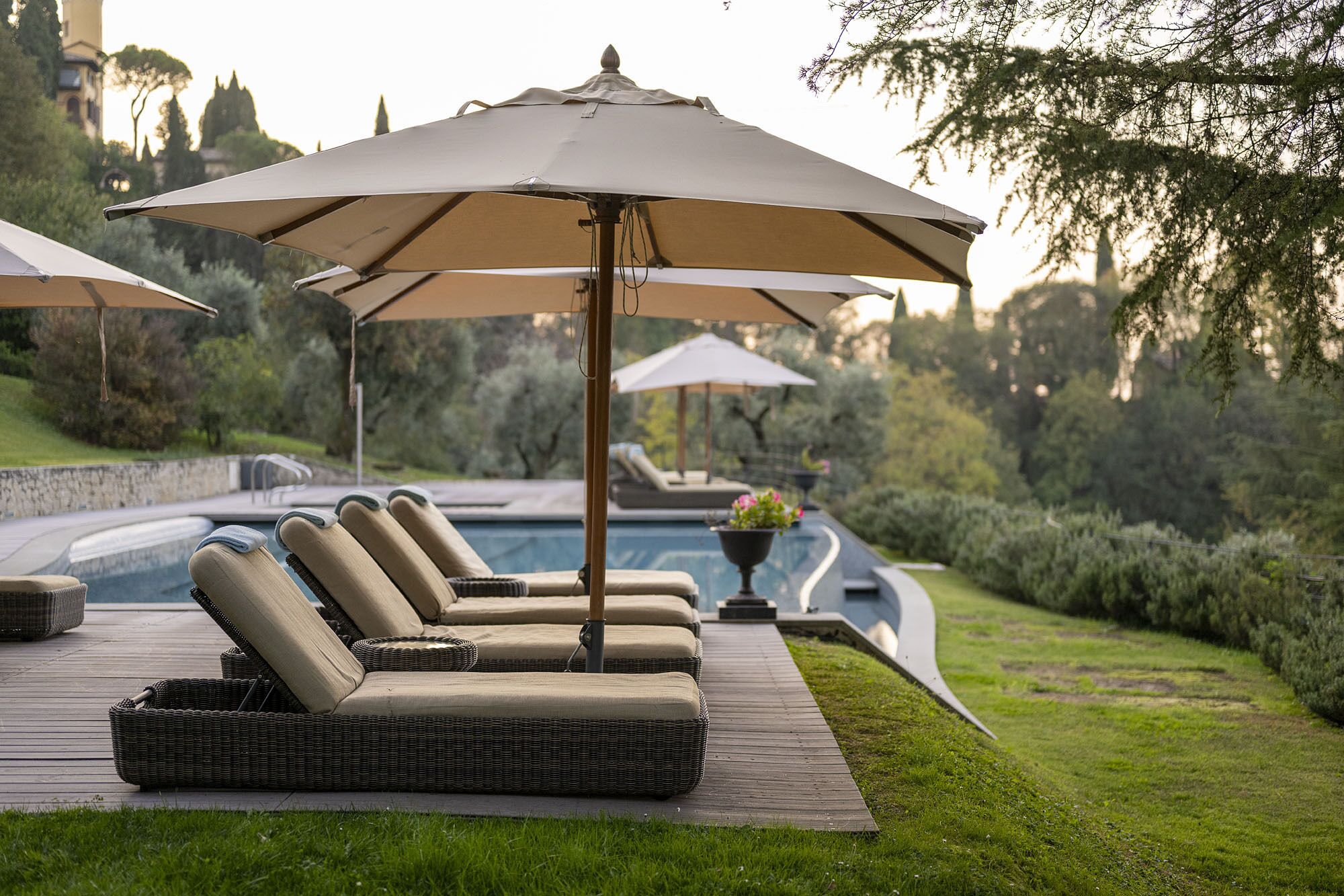 A poolside area with lounge chairs and umbrellas.
