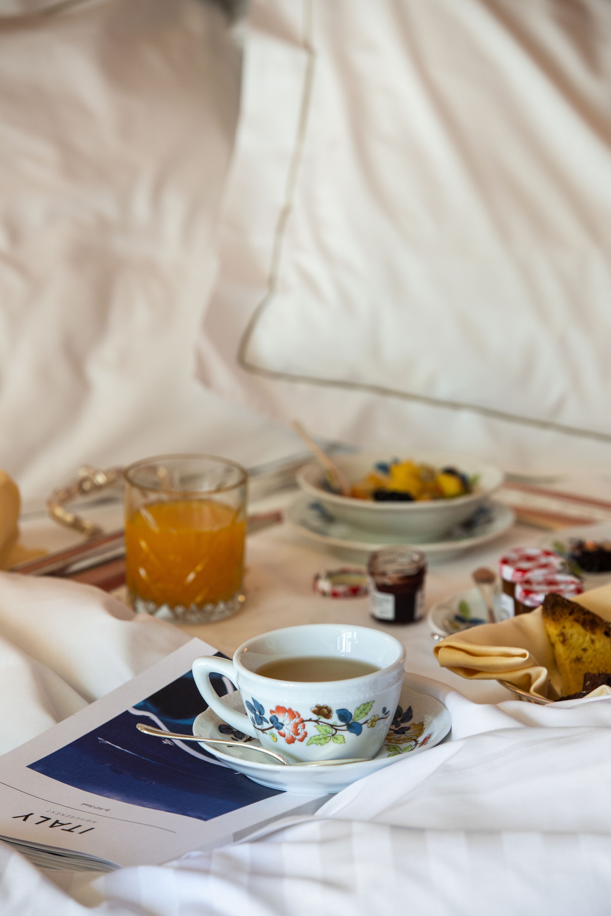 Colazione in camera: una tazza di caffè, un bicchiere di succo d'arancia e un piatto di cibo.